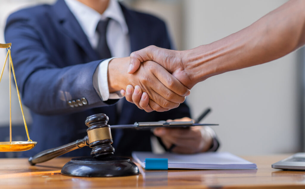 Lawyer and client handshake after winning lemon case