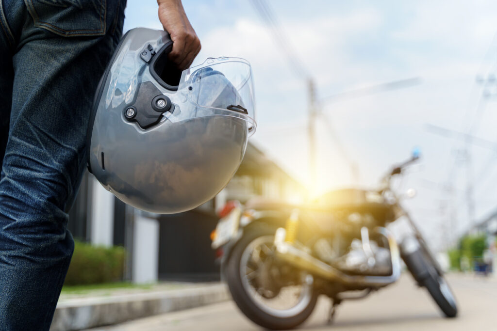 Motorcyclist holding helmet with California lemon law focus