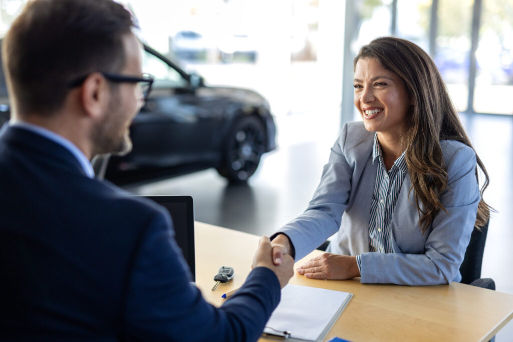 Car, dealership or documents with salesman and customer