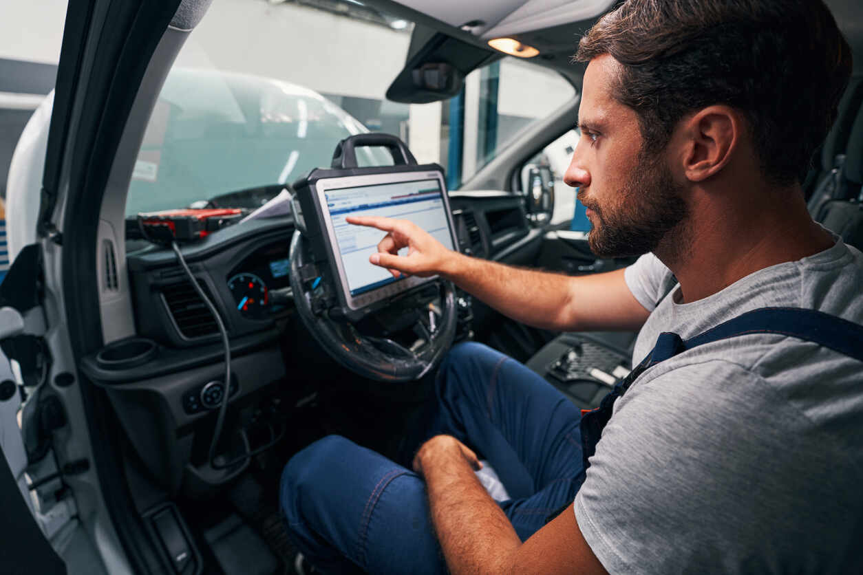 A person performing a diagnostic check on a car's infotainment system, representing common software issues leading to safety concerns and lemon law claims.