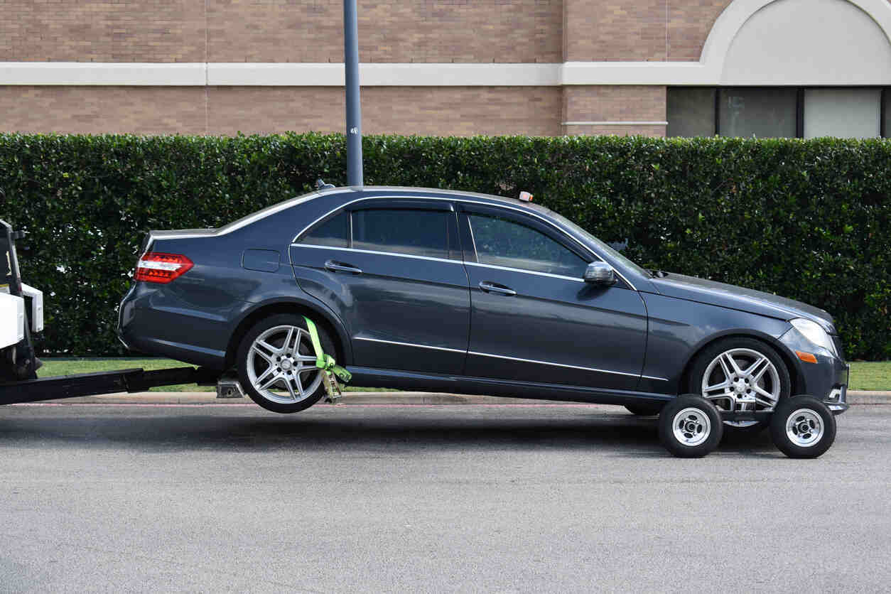 A blue Mercedes-Benz being towed, symbolizing a persistent car problem requiring dealer attention.